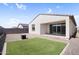 View of the home's manicured backyard with artificial turf and private block fencing at 11341 E Unger Ave, Mesa, AZ 85212