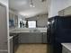 Well-lit kitchen features stainless dishwasher and refrigerator and neutral cabinets flowing into open living area at 1137 W 21St Ave, Apache Junction, AZ 85120