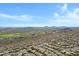 Expansive aerial shot showcasing a community with a golf course, surrounded by natural desert landscape and distant mountains at 11413 S Coolwater Dr, Goodyear, AZ 85338