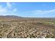 Expansive aerial view of a suburban desert community with mountain views and tiled rooftops at 11413 S Coolwater Dr, Goodyear, AZ 85338