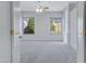 Spacious bedroom with neutral carpet, two windows, ceiling fan, and white walls at 11413 S Coolwater Dr, Goodyear, AZ 85338
