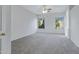 Spacious bedroom with neutral carpet, two windows, ceiling fan, and white walls at 11413 S Coolwater Dr, Goodyear, AZ 85338