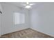 Bright bedroom featuring neutral carpet, white walls, and a ceiling fan with integrated lighting at 11413 S Coolwater Dr, Goodyear, AZ 85338