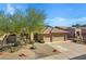 Home featuring a desert landscape, solar panels and a convenient two-car garage at 11413 S Coolwater Dr, Goodyear, AZ 85338