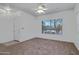 Neutral living room features a large window and a ceiling fan, providing a serene and comfortable space at 11413 S Coolwater Dr, Goodyear, AZ 85338