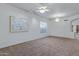Spacious living room features neutral carpet, a chandelier, and a large picture window for natural light at 11413 S Coolwater Dr, Goodyear, AZ 85338