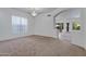 Bright, open living room featuring neutral carpet, a chandelier, and an arched doorway to the dining area at 11413 S Coolwater Dr, Goodyear, AZ 85338