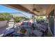 Expansive covered back patio with ample seating, a ceiling fan, and a beautifully landscaped backyard at 12950 W Quinto Dr, Sun City West, AZ 85375