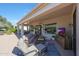 Inviting covered back patio with comfortable seating, a built-in TV, and a beautifully landscaped yard at 12950 W Quinto Dr, Sun City West, AZ 85375
