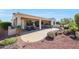 Well-maintained backyard with a patio area, flowers, desert landscaping, and a calming water feature at 12950 W Quinto Dr, Sun City West, AZ 85375