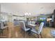 Open-concept dining area with stylish lighting, a wooden table, and seamless access to the kitchen and living spaces at 12950 W Quinto Dr, Sun City West, AZ 85375