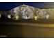 Charming home featuring accent lighting and lush landscaping, creating a welcoming nighttime ambiance at 12950 W Quinto Dr, Sun City West, AZ 85375