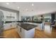 Well-lit kitchen with a central island, white cabinets, granite countertops, and an open layout to the living area at 12950 W Quinto Dr, Sun City West, AZ 85375