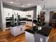 Spacious kitchen features white cabinets, stainless steel appliances, and a large island with a black countertop at 12950 W Quinto Dr, Sun City West, AZ 85375