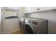 Well-lit laundry room with modern, front-load washer and dryer at 12950 W Quinto Dr, Sun City West, AZ 85375