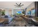 Open-concept living room featuring dual sofas, modern decor, and a large window view to the backyard at 12950 W Quinto Dr, Sun City West, AZ 85375