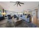 Cozy living room with plush seating, a ceiling fan, and an open layout flowing to the dining and kitchen areas at 12950 W Quinto Dr, Sun City West, AZ 85375