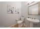 Stylish powder room with contemporary fixtures, unique wall art, and a pedestal sink at 12950 W Quinto Dr, Sun City West, AZ 85375
