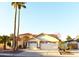 Charming single-story home featuring a three-car garage, tile roof, and lush palm trees at 1490 W Laurel Ave, Gilbert, AZ 85233