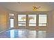 Open living room with tile flooring, ceiling fan and three large bright windows at 1490 W Laurel Ave, Gilbert, AZ 85233