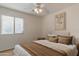 Neutral bedroom featuring ceiling fan, large window, queen bed, and decorative artwork at 1642 E Cardinal Dr, Casa Grande, AZ 85122