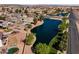 Community aerial view showcases a neighborhood with mature trees, a lake, and recreational areas at 17043 N Avelino Dr, Maricopa, AZ 85138