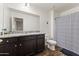 This bathroom features a granite vanity, modern lighting, and a shower with a blue and white patterned curtain at 17043 N Avelino Dr, Maricopa, AZ 85138