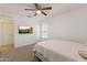 Bedroom with neutral walls and carpet, ceiling fan, and a wall-mounted TV for relaxation at 17043 N Avelino Dr, Maricopa, AZ 85138