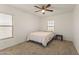 Bright bedroom with neutral walls, featuring two windows, a bed, and a ceiling fan, offering comfort and style at 17043 N Avelino Dr, Maricopa, AZ 85138