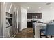 Kitchen with stainless steel appliances, dark wood cabinets, hardwood floors, and a large granite island with seating at 17043 N Avelino Dr, Maricopa, AZ 85138
