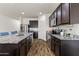 Spacious kitchen with stainless steel appliances, granite countertops, hardwood floors, and dark wood cabinets at 17043 N Avelino Dr, Maricopa, AZ 85138