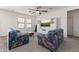 Cozy living room showcasing plush paisley couches, a ceiling fan and a wall unit with a large screen TV at 17043 N Avelino Dr, Maricopa, AZ 85138