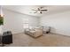 Bright living room with neutral walls, carpet, ceiling fan, and comfortable, reclining leather furniture at 17043 N Avelino Dr, Maricopa, AZ 85138