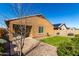 A manicured backyard with a brick patio, green lawn, and desert landscaping, offering a private outdoor space at 1739 E Elegante Dr, Casa Grande, AZ 85122