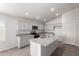 Well-lit kitchen featuring a large island, stainless appliances, granite counters and white cabinets at 1739 E Elegante Dr, Casa Grande, AZ 85122
