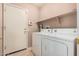 A well-lit laundry room features a white washer and dryer set with shelving above at 1775 E Sycamore Rd, Casa Grande, AZ 85122