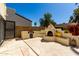 Backyard featuring a custom stucco fireplace, built-in seating, and lush greenery, ideal for outdoor entertaining at 1839 E Vinedo Ln, Tempe, AZ 85284