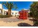 Lush backyard with a red gazebo, desert landscaping, and a tall palm tree creating a tranquil retreat at 1839 E Vinedo Ln, Tempe, AZ 85284