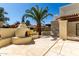 Scenic backyard with a stucco fireplace, seating, a large palm tree and a paved patio, perfect for relaxation at 1839 E Vinedo Ln, Tempe, AZ 85284