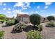 Home's backyard featuring easy care desert landscaping, mature trees and block wall fencing at 19722 N Regents Park Dr, Surprise, AZ 85387