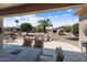 Back patio area featuring a waterfall landscape, seating, and lush greenery, perfect for outdoor relaxation at 19722 N Regents Park Dr, Surprise, AZ 85387