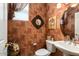 Cozy powder room with decorative wallpaper, ornate mirror, and pedestal sink at 19722 N Regents Park Dr, Surprise, AZ 85387