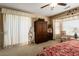 Spacious bedroom featuring neutral walls and carpet, with a wooden armoire and plenty of natural light at 19722 N Regents Park Dr, Surprise, AZ 85387