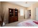 Neutral bedroom with a wooden bookcase, carpeted floors, and open doorway at 19722 N Regents Park Dr, Surprise, AZ 85387