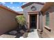 Inviting entryway featuring a secure screen door, neutral tones, and desert landscaping for a welcoming appeal at 19722 N Regents Park Dr, Surprise, AZ 85387