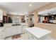 Bright kitchen featuring white cabinets, marble countertops, tile flooring and a center island at 19722 N Regents Park Dr, Surprise, AZ 85387