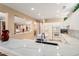 Bright kitchen featuring white cabinets, marble countertops and a large island with sink at 19722 N Regents Park Dr, Surprise, AZ 85387