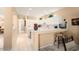 Clean white kitchen with breakfast bar seating and tile flooring, perfect for casual dining at 19722 N Regents Park Dr, Surprise, AZ 85387