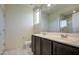 Bright bathroom featuring a double vanity with dark cabinets, tile floors, and a glass shower at 20162 W Buchanan St, Buckeye, AZ 85326