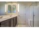 Shows a bathroom featuring double sinks, tiled floors, a glass-enclosed shower, and neutral-colored walls at 20162 W Buchanan St, Buckeye, AZ 85326